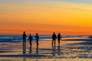 Family walking the beach at sunset at North Topsail Beach